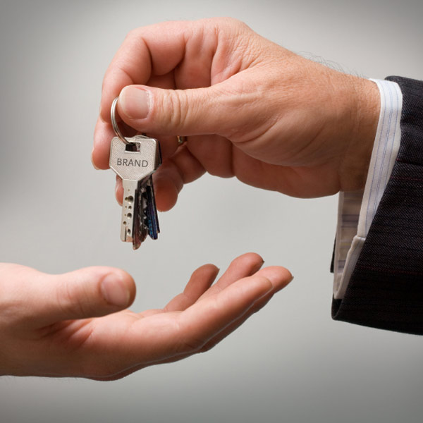 Hand giving keys to another person